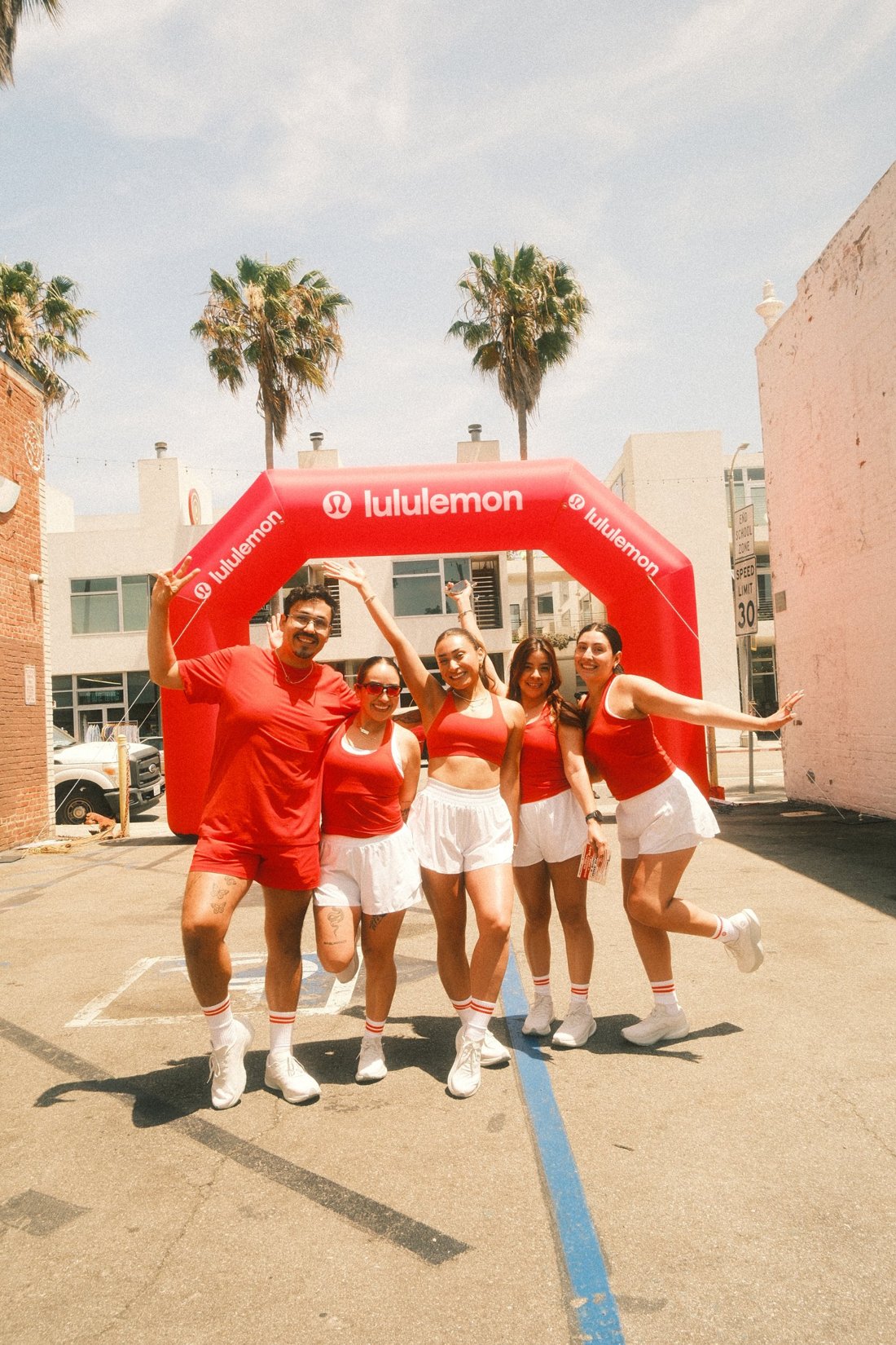 The Ceiba y Sol team laughing and posing in matching red and white outside under palm trees